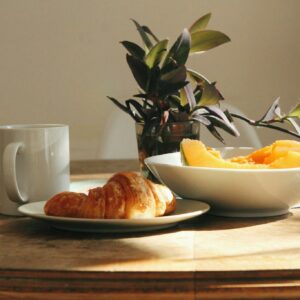 Fresh fruit and croissant on wooden table